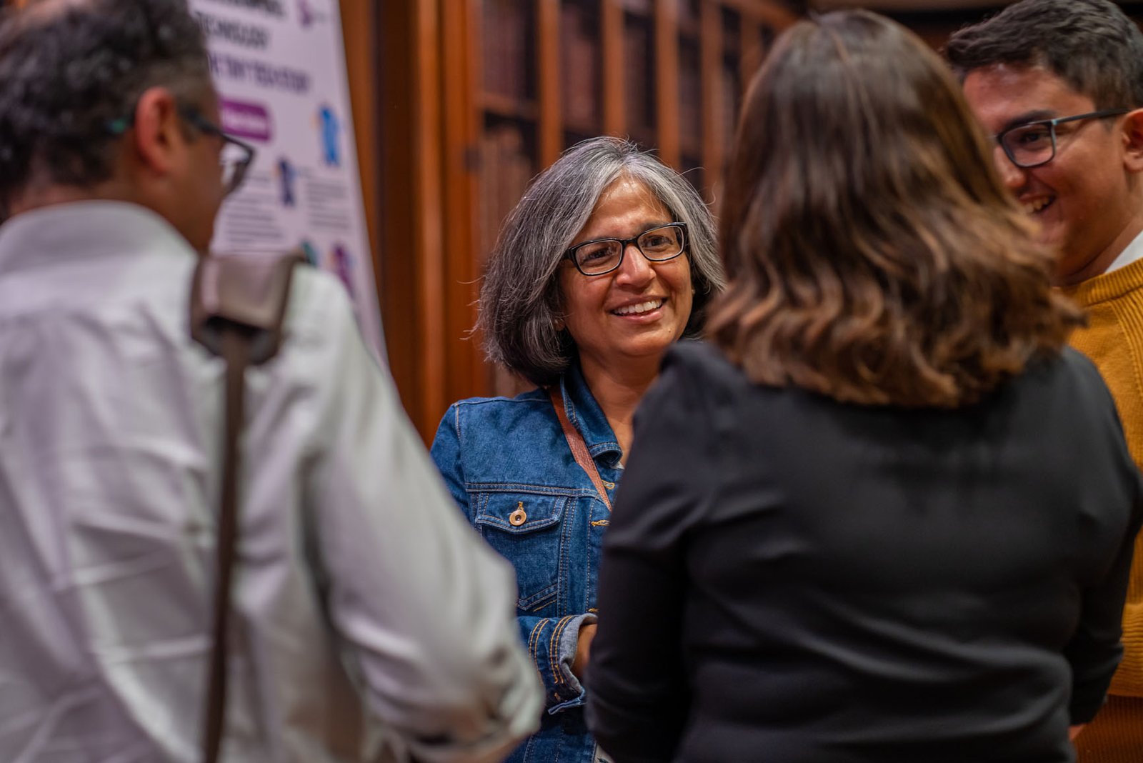 A group of smiling people talking to one another at a living kidney donation awareness raising event