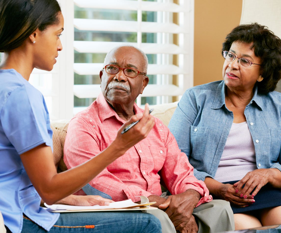 A healthcare professional talking to two patients