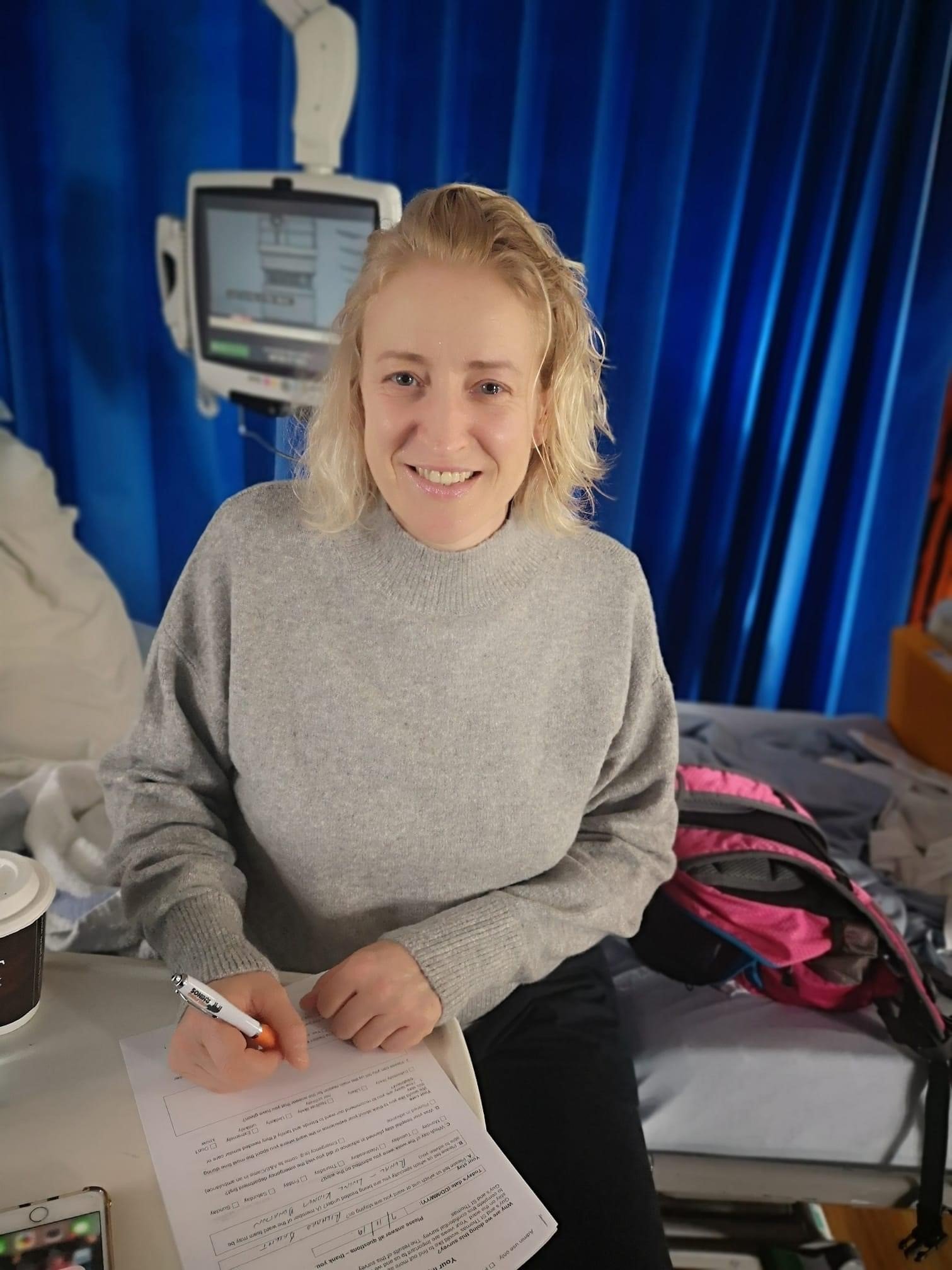 Living kidney donor Liz filling out paperwork in hospital on the day of her transplant