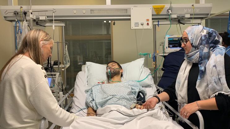 Living kidney recipient Mark asleep in hospital with his family around him