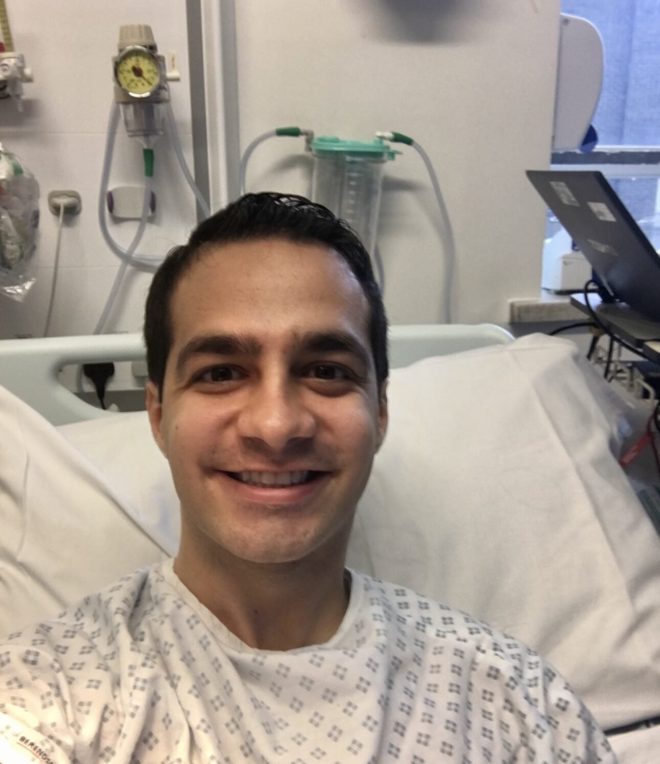 Living kidney donor Ali in a hospital bed smiling at the camera