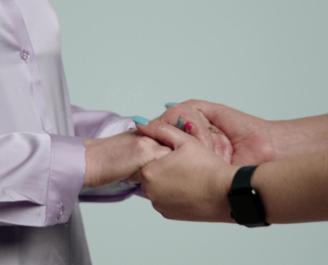 Image of two people holding hands